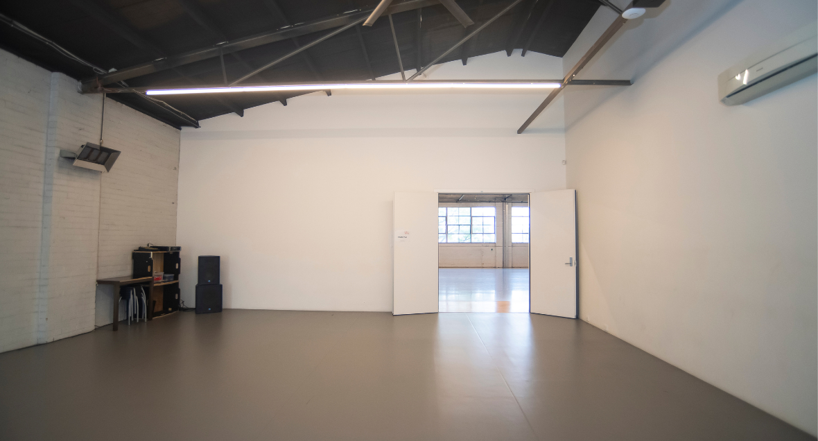 Wheelchair Accessible Rehearsal space, North Melbourne. A white and grey studio with ramp with thin light beams.