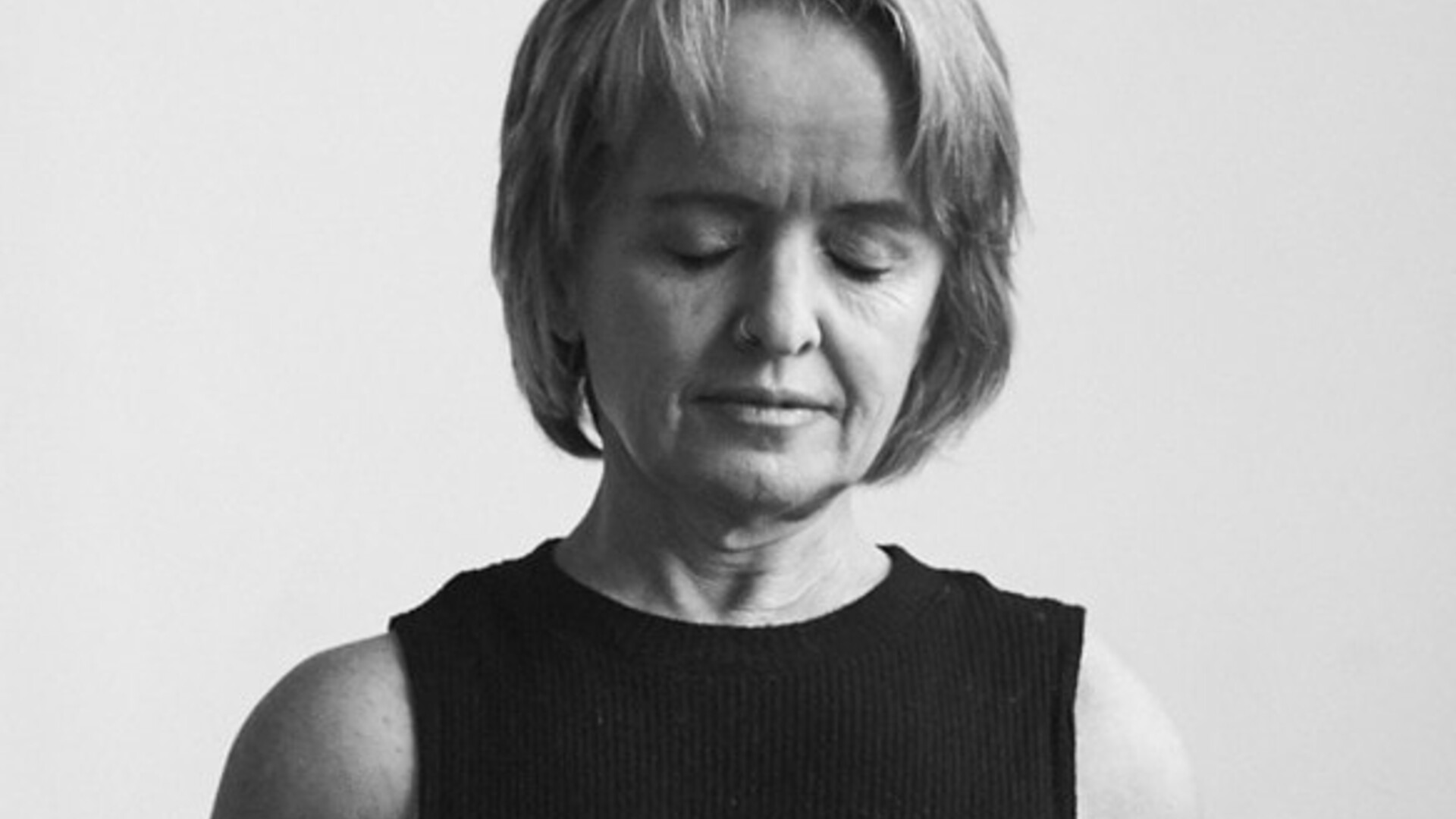 A black and white portrait of Leisa Prowd. Leisa's eyes are closed, and her facial expression is calm.