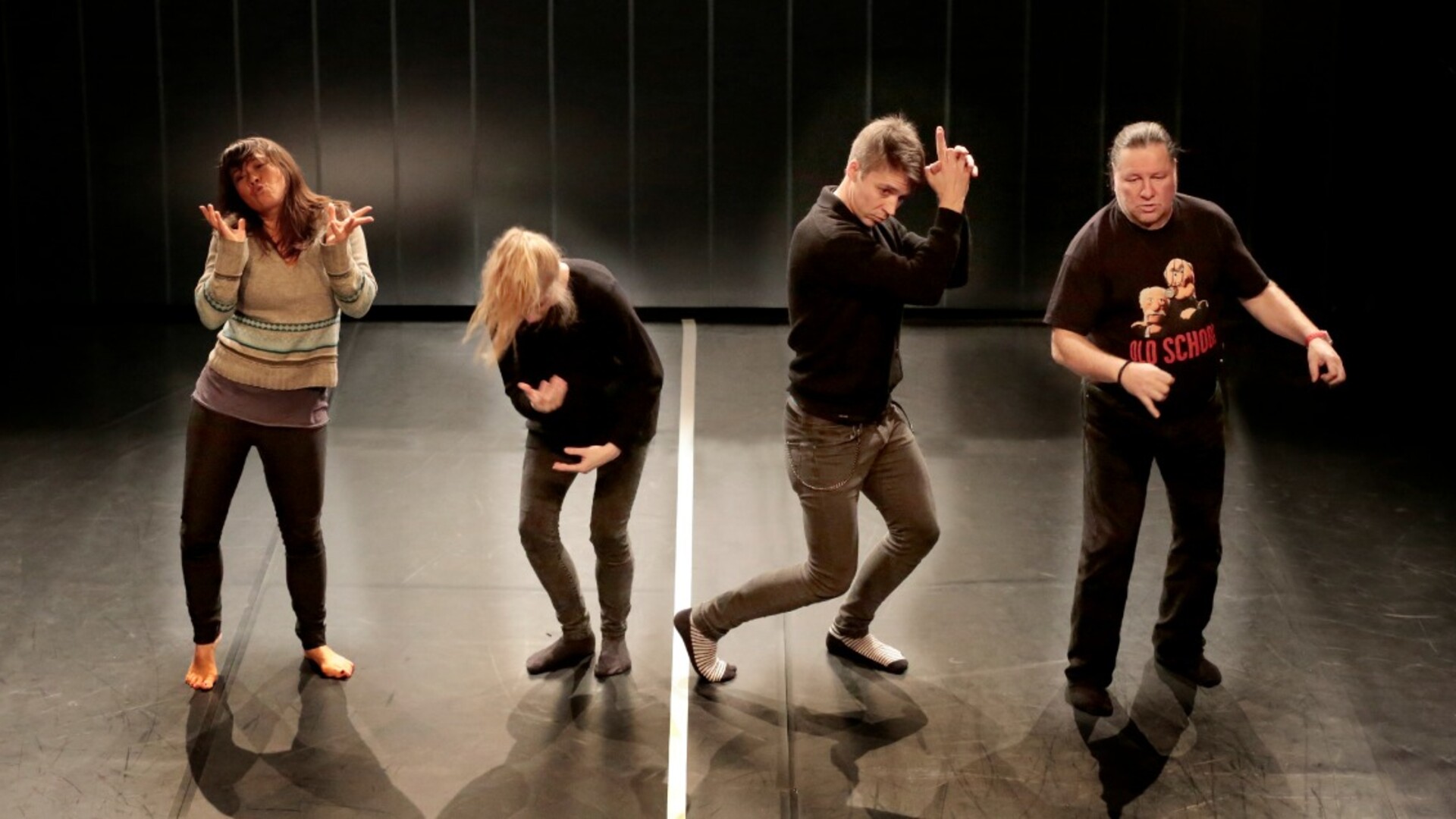 Four performers stand in different positions.