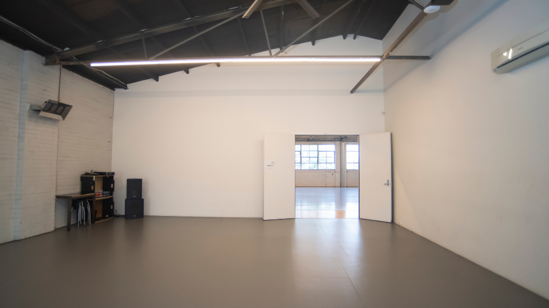 Wheelchair Accessible Rehearsal space, North Melbourne. A white and grey studio with ramp with thin light beams.